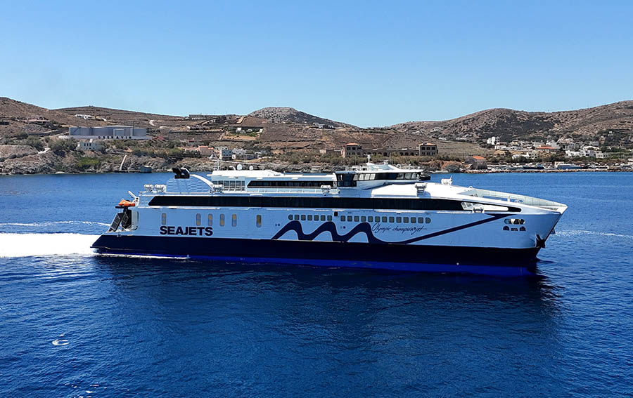 SeaJets ferry cruising through the Aegean Sea near Mykonos, with the island’s picturesque landscape in the background.