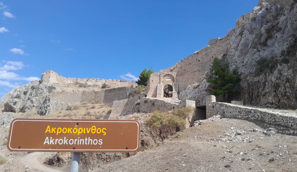 The entry pathway and sign leading to Acrocorinth, the ancient fortress on a high hill overlooking Corinth.