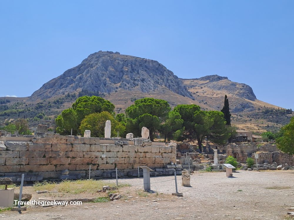 Wide view of the Apostle Paul's bema ruins with Acrocorinth mountain in the background.