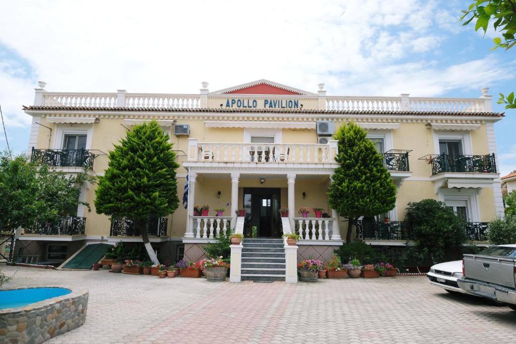 Front view of Apollo Pavilion Hotel in Lemnos, showcasing its traditional architecture and garden-lined entrance.