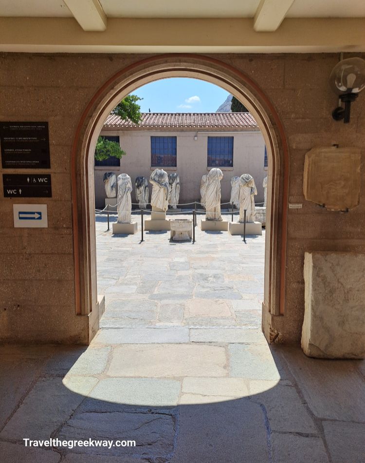 View through an archway leading to the museum courtyard with ancient statues.