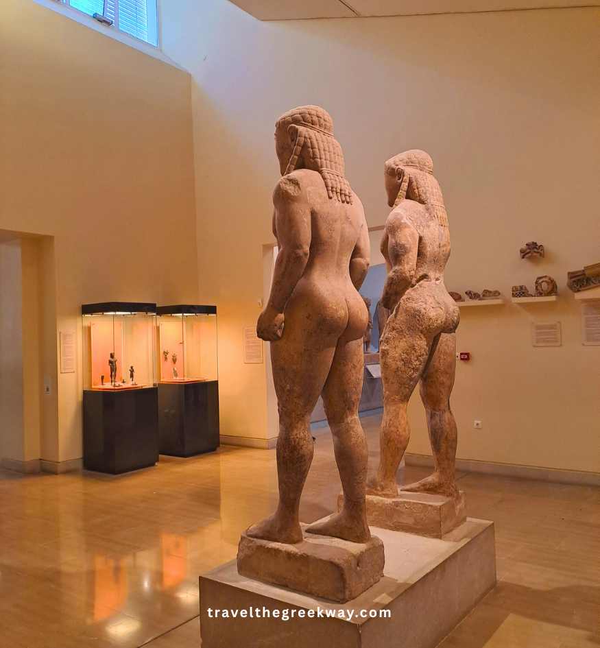Two ancient marble Kouroi statues (Kleobis and Biton) viewed from behind in the Delphi Archaeological Museum, Central Greece.