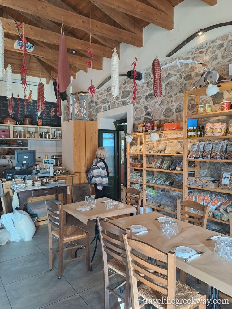 Traditional Greek deli and tavern interior with hanging sausages and local products in Chalkida.