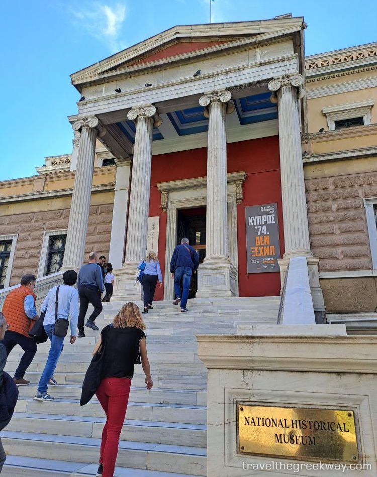 The entrance of the National Historical Museum of Athens, with visitors climbing the marble steps.