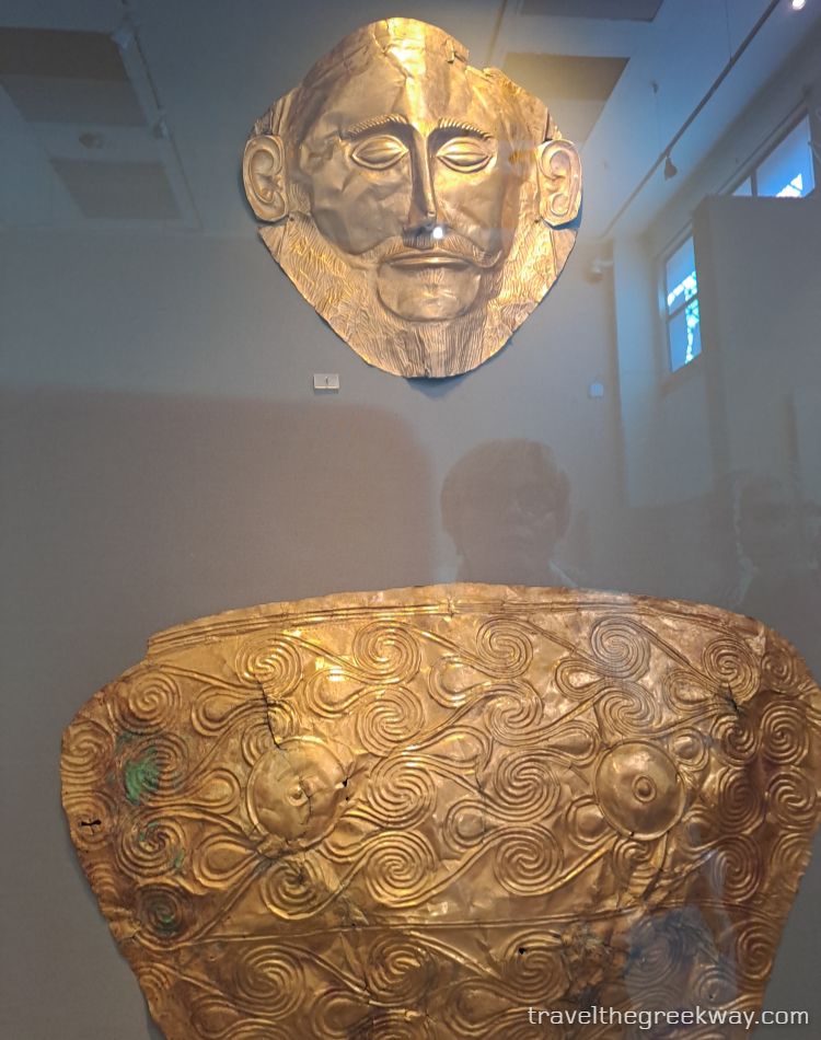 Golden funerary mask, breastplate, and decorated cup from Mycenae on display at the National Archaeological Museum in Athens.
