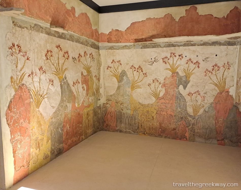 Colorful wall fresco of spring lilies and swallows from Akrotiri, Santorini, displayed at the National Archaeological Museum in Athens.