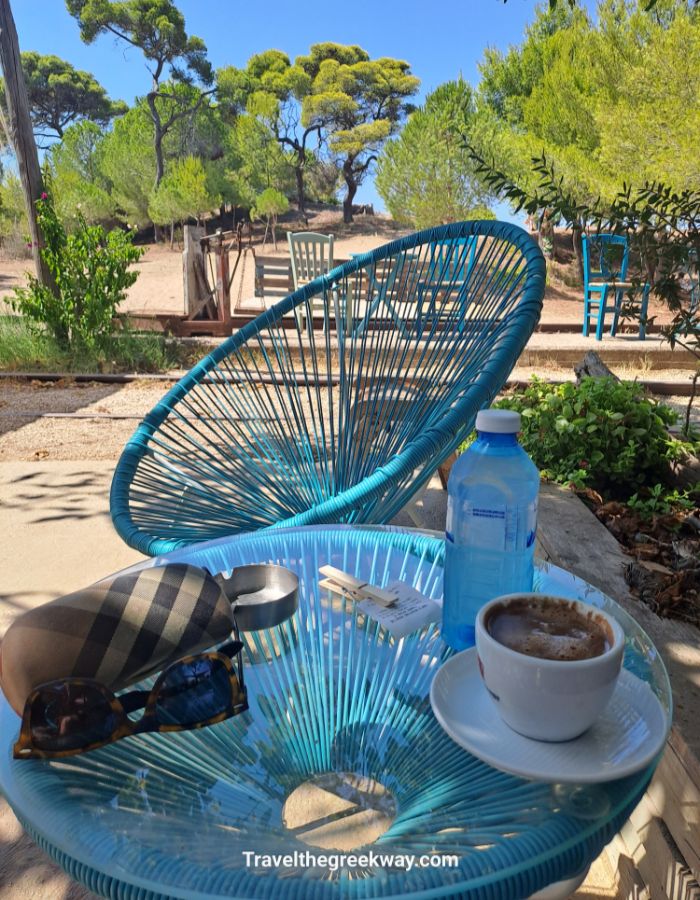 Coffee and water on a blue chair table at Kaiafas beach café.