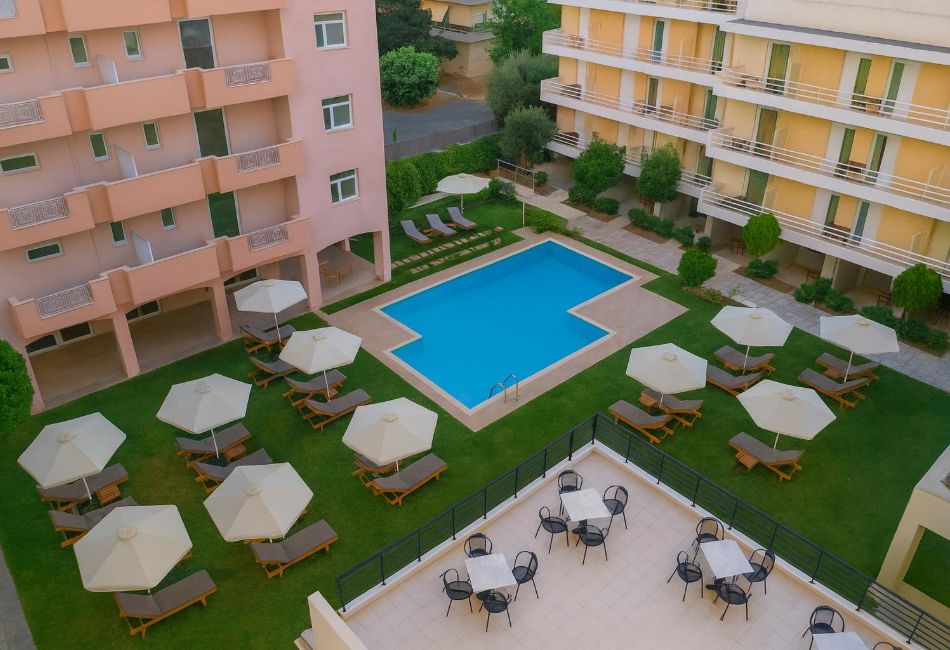 Aerial view of hotel swimming pool with umbrellas and garden in Marousi, Athens.