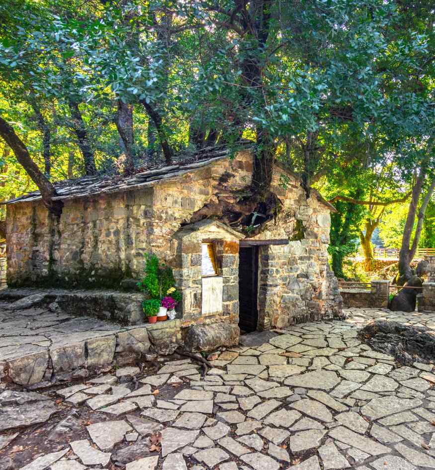 The miraculous chapel of Agia Theodora in Vasta, Arcadia, with 17 giant trees growing from its stone roof without visible roots.