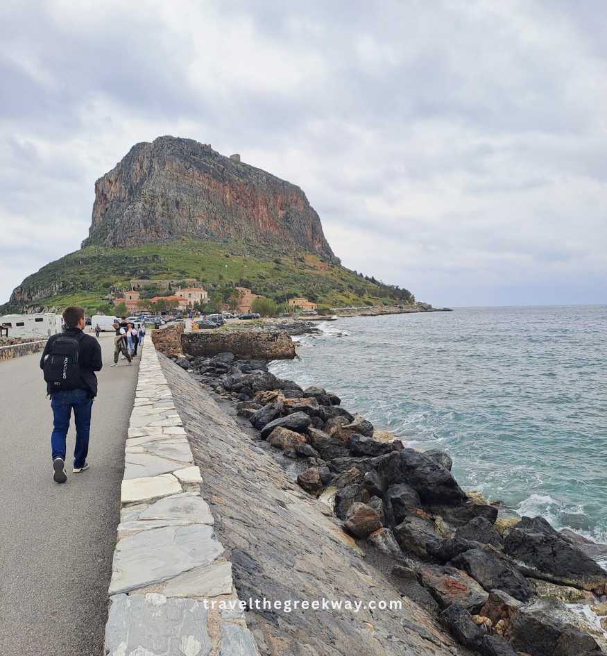 A tourist walking along the stone bridge causeway leading to Monemvasia, Peloponnese Greece.