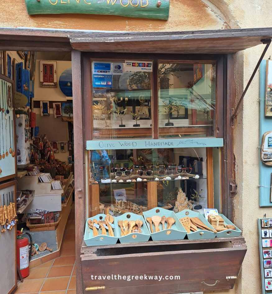 A local souvenir shop window displaying handmade olive wood utensils in Monemvasia, Peloponnese Greece.