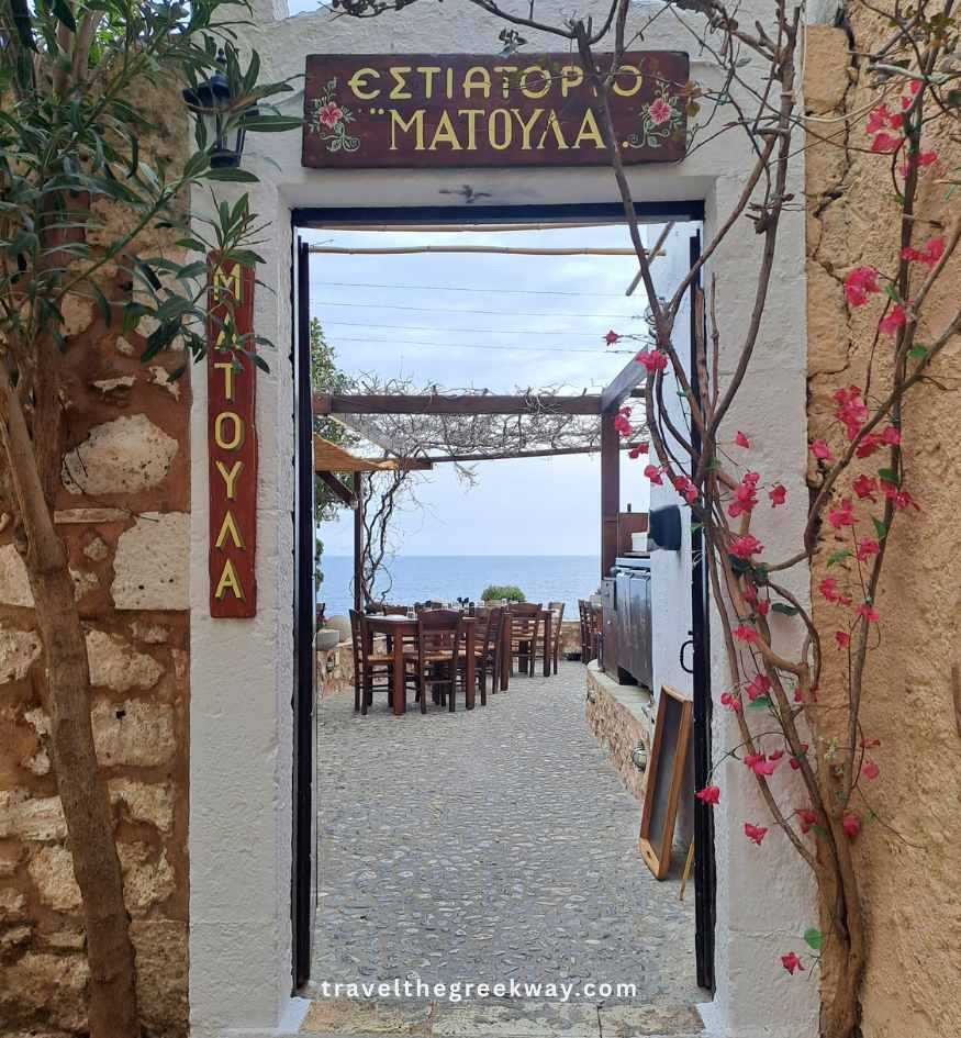 The stone archway entrance to Matoula restaurant with sea views in Monemvasia, Peloponnese Greece.