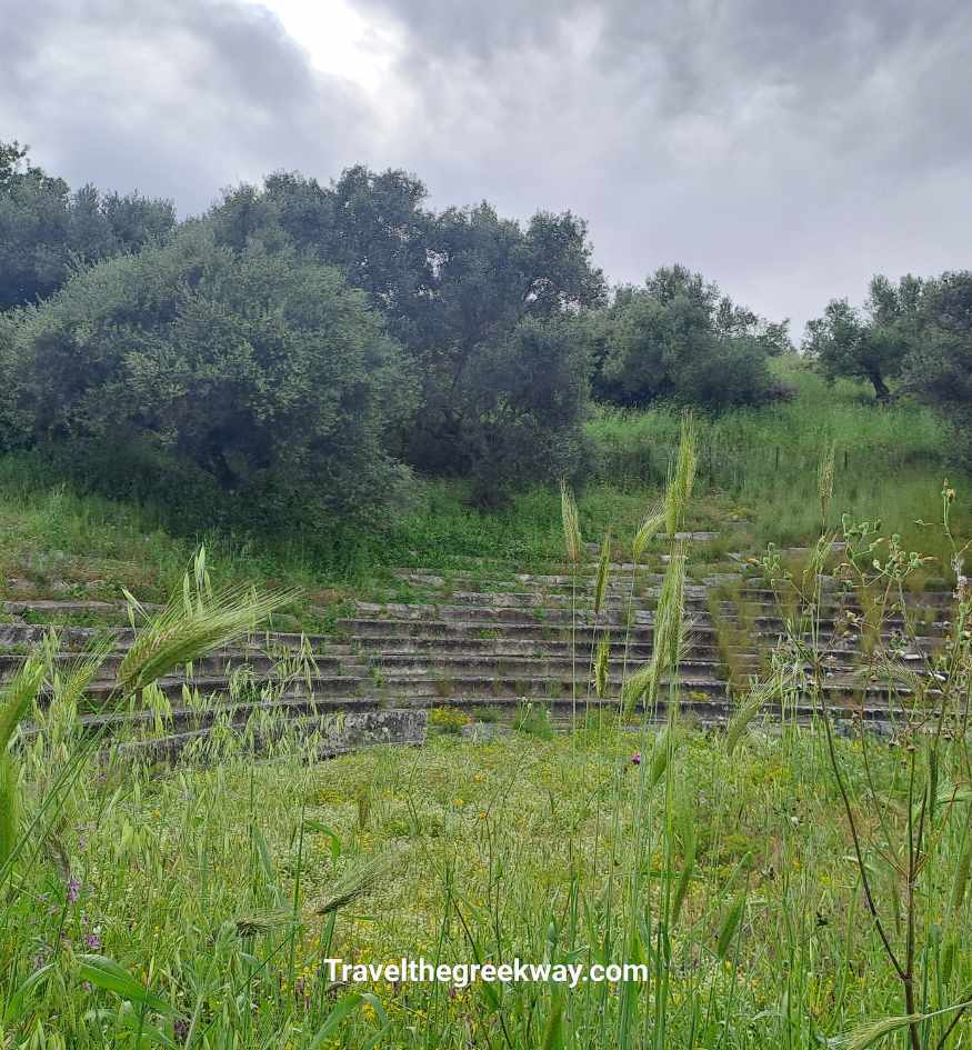 Ruins of the ancient theater of Gythio surrounded by wild grass and olive trees in the Peloponnese, Greece.