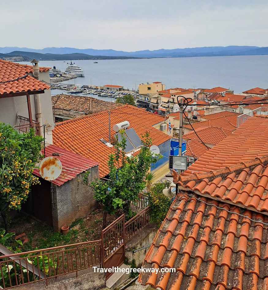 Panoramic view over the red-tiled rooftops of Gythio toward the harbor, sea and mountains of the Mani Peninsula.
