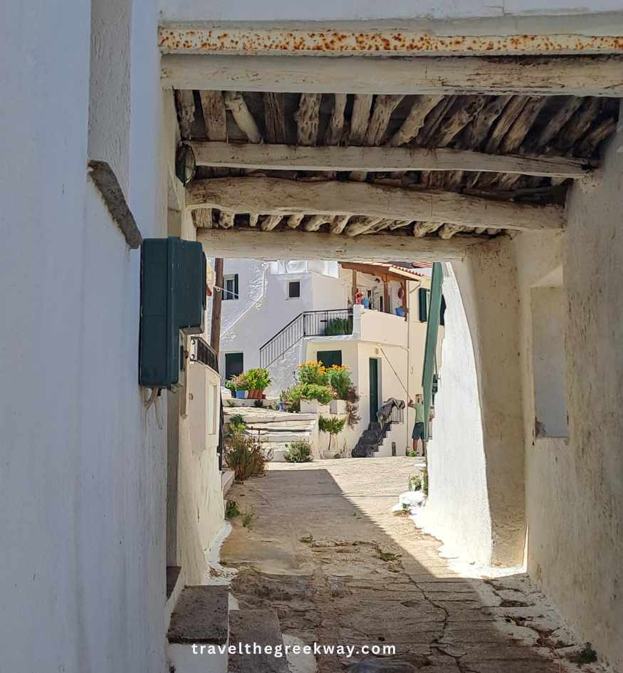 Traditional covered stone passage with wooden ceiling beams, whitewashed walls and steps between houses in Ioulida, Kea, Greece.