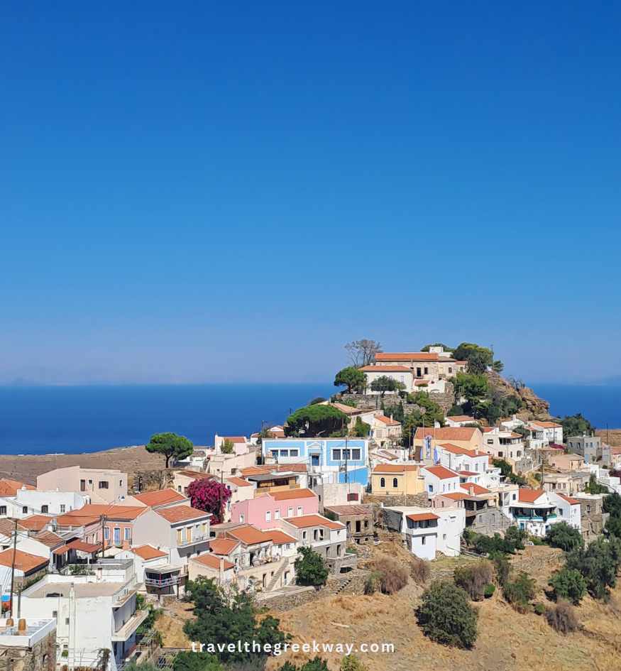 Panoramic view over the colorful hillside houses of Ioulida on Kea island, with the deep blue Aegean Sea in the background, Greece.